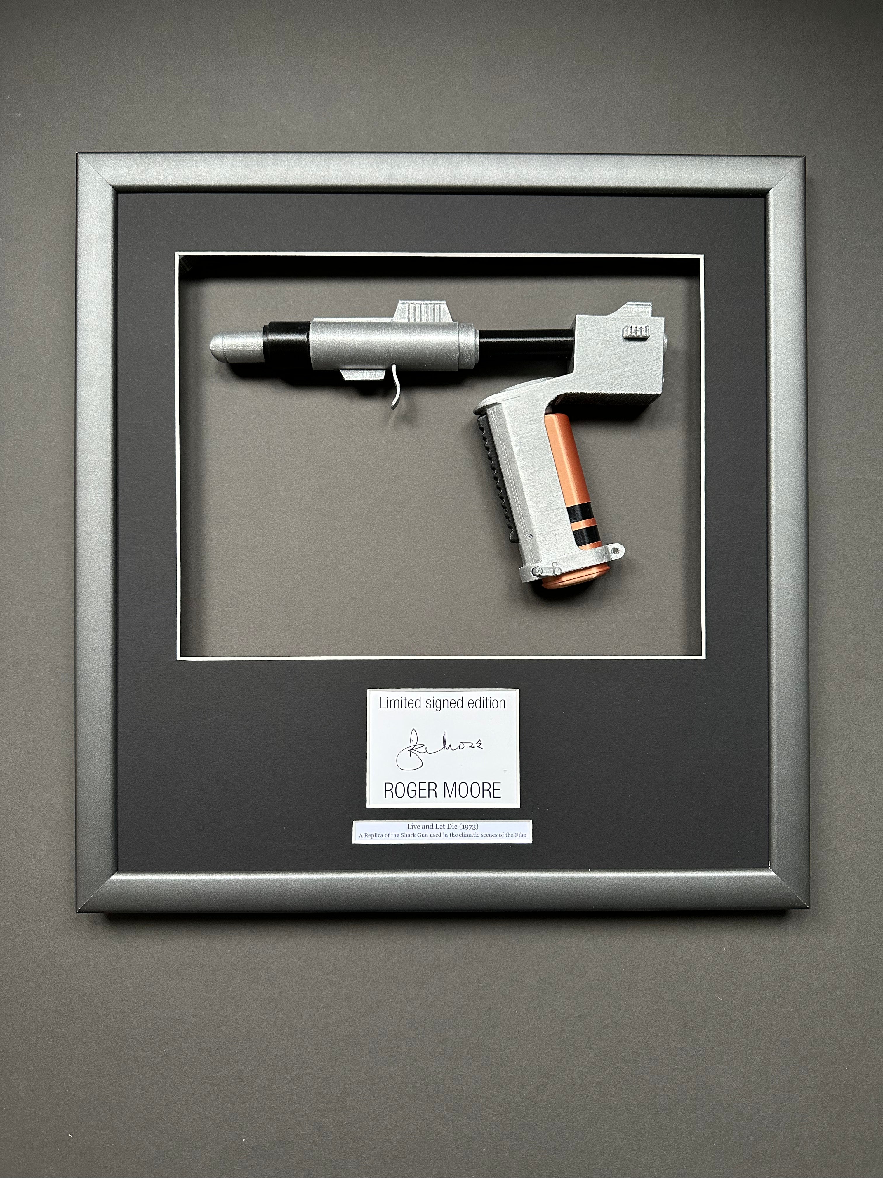 A James Bond Movie Prop Replica in a bespoke Framed Display with an autograph of Roger Moore.
