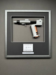A James Bond Movie Prop Replica in a bespoke Framed Display with an autograph of Roger Moore.